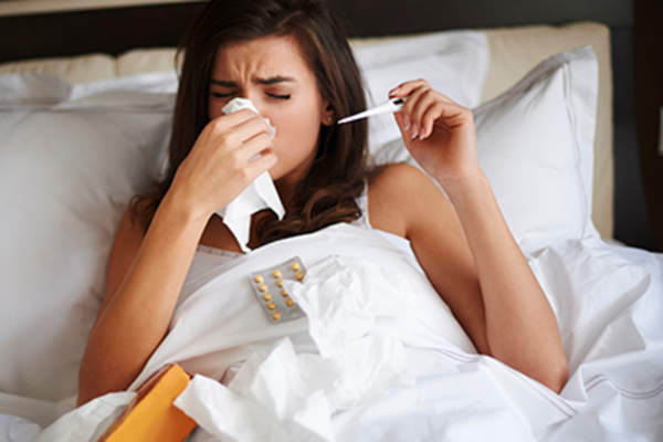 一个女人躺在床上,流着鼻涕,还发烧。