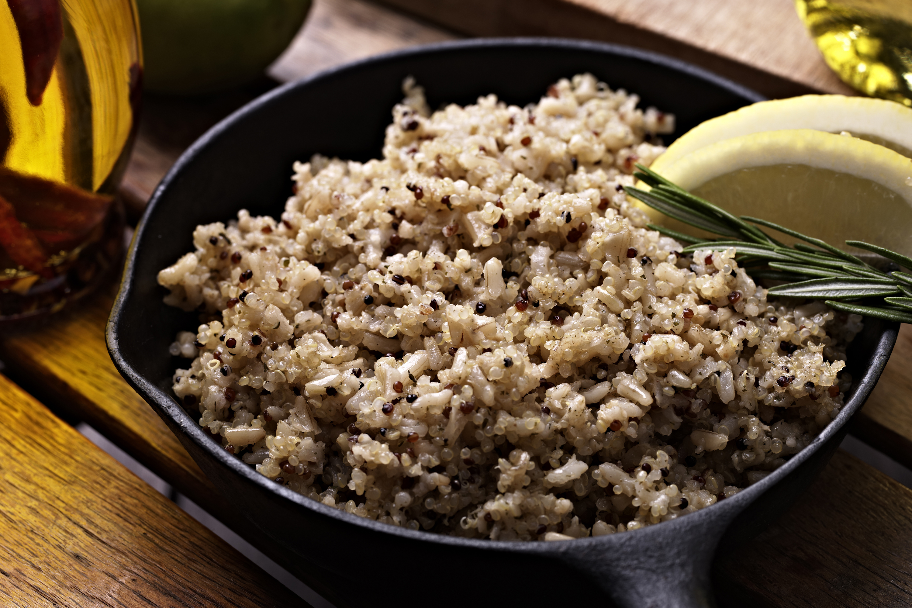 A cast-iron skillet containing cooked quinoa sits on a countertop.