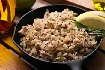 A cast-iron skillet containing cooked quinoa sits on a countertop.