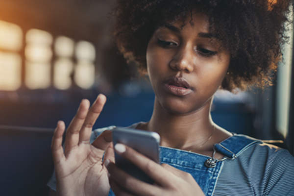 年轻女子的消息上的智能手机。