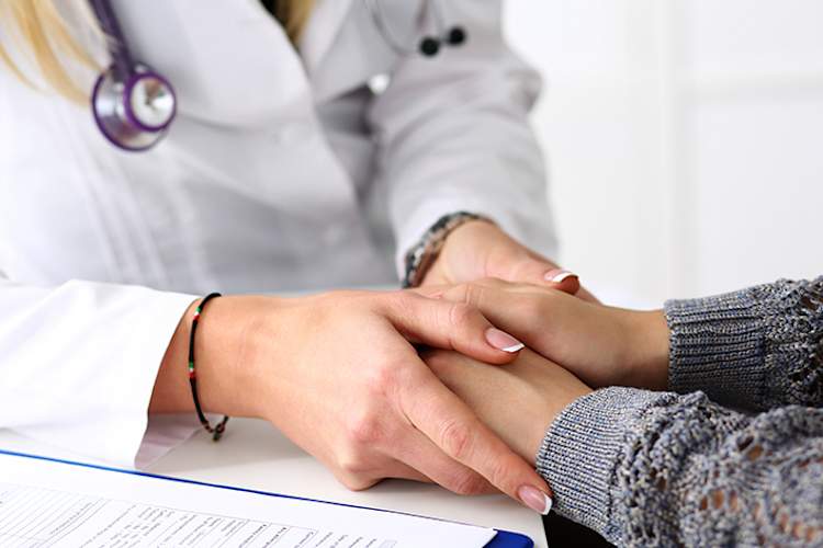 医生牵着一位女病人的手。