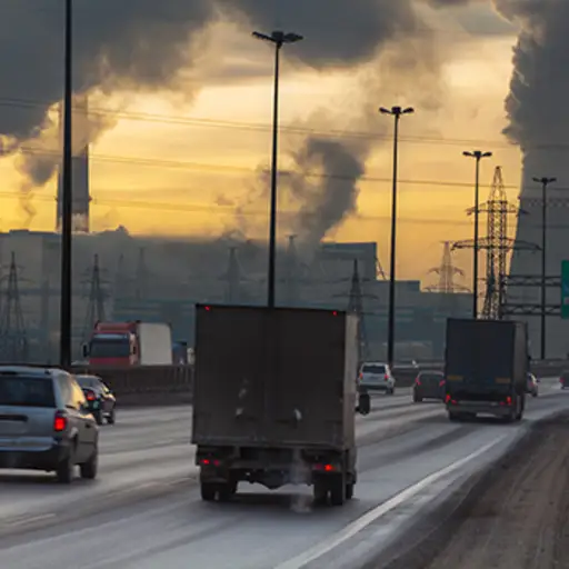 Cars and trucks on road with air pollution.