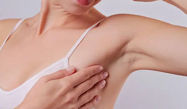 一个女人正在摸她的腋窝有没有肿块。