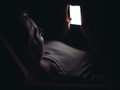床上的智能手机看护人。