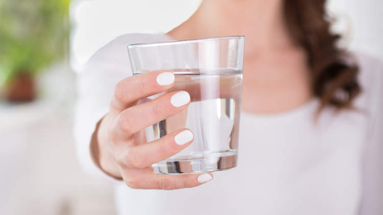 女人端着一杯水。