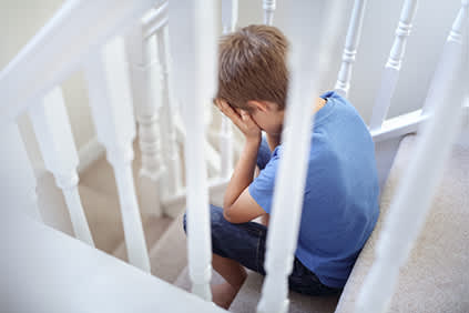 创伤小男孩在哭在楼梯上。