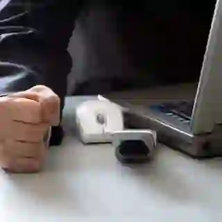 Person at computer with a hand clenched into a fist