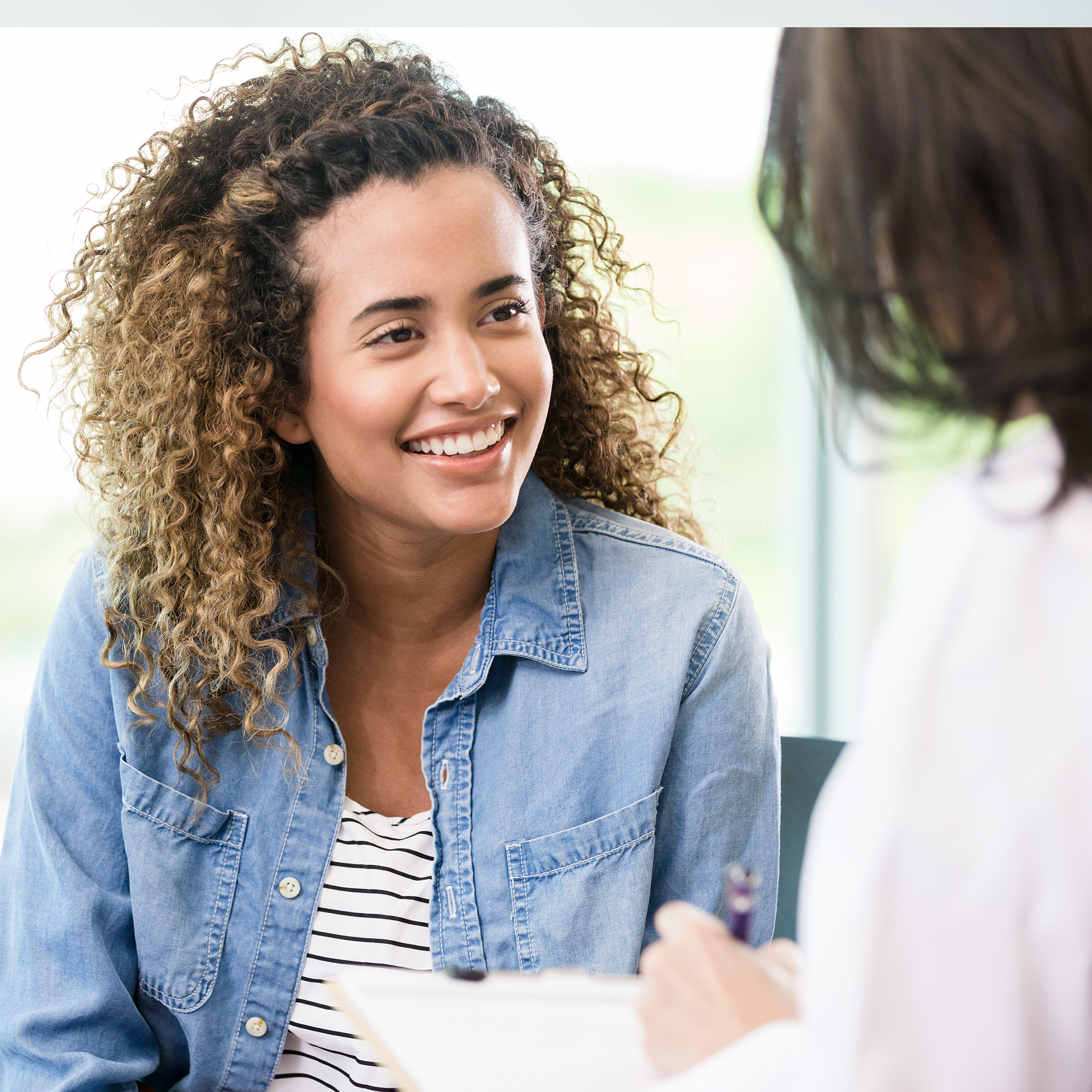 一个微笑的女病人聚精会神地听医生给了她一个好消息。
