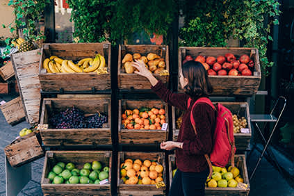 女人从市场挑选新鲜水果。