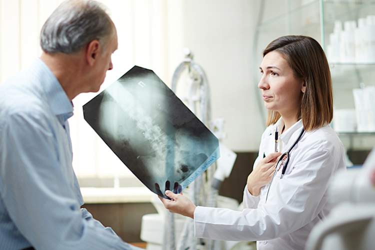 医生给一位老年病人做肺部x光检查。