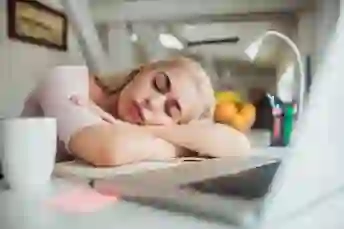 女人在笔记本电脑面前小睡