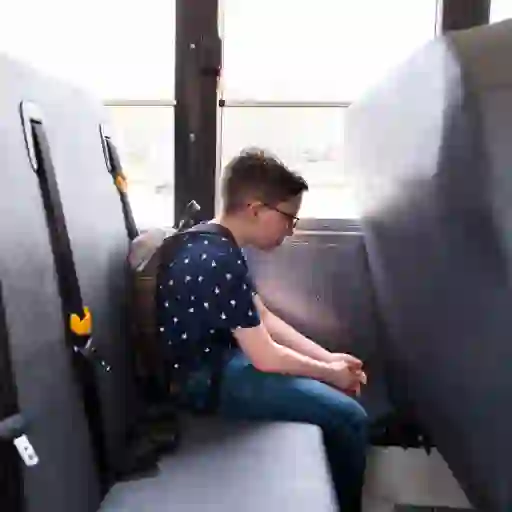 悲伤，担心的男孩坐在公共汽车上。