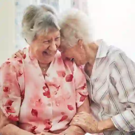 两个年长的女人笑着拥抱着