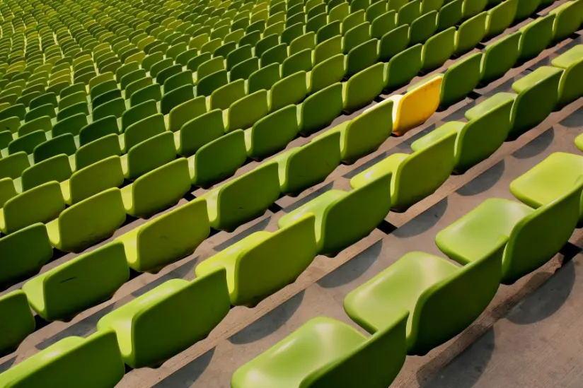 在一个体育场的绿色椅子有一把黄色椅子的