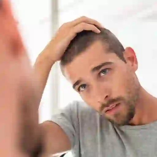 一个男人对着镜子检查他的头发