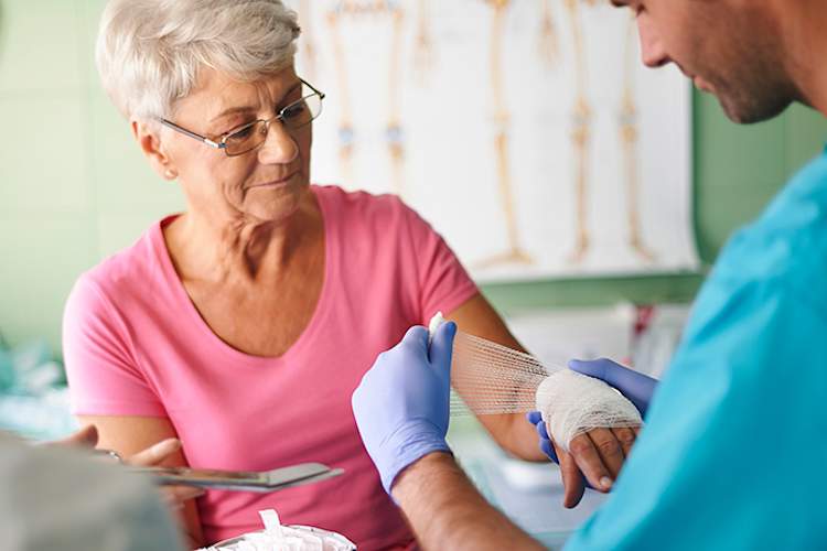 医生包裹的资深女人的手腕。