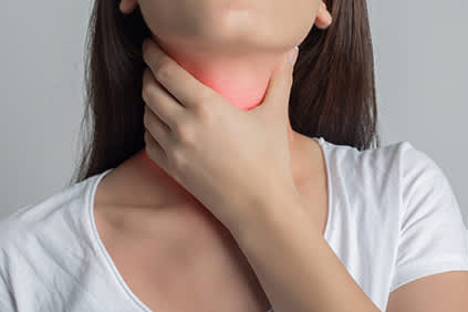 女人抱着她的脖子咽喉，甲状腺，或颈部疼痛。