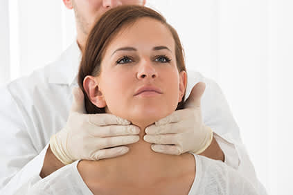 医生妇女进行甲状腺检查。
