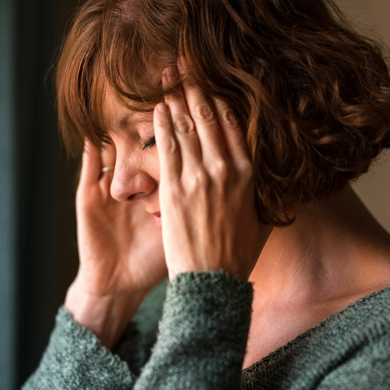 一个女人闭上眼睛,揉她的寺庙