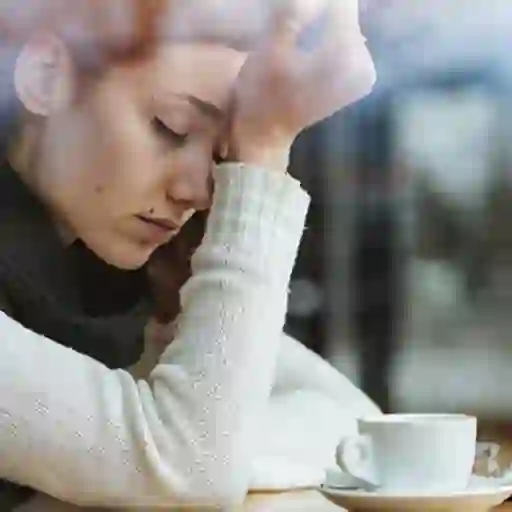 Tired young woman with coffee.