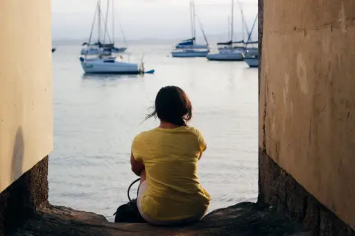 Woman sitting alone near water