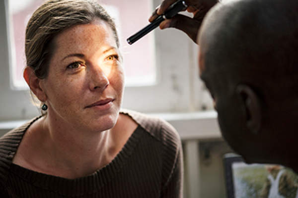 Doctor checking a woman's vision.