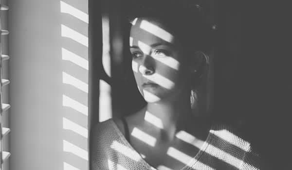 女人广场恐怖症望着窗外的形象。