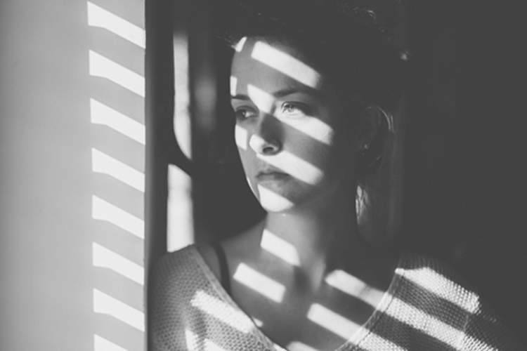 女人广场恐怖症望着窗外的形象。