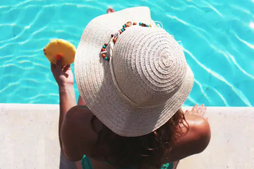 放松在游泳的假期的太阳帽子的妇女。