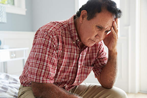 不幸的人坐在床上。