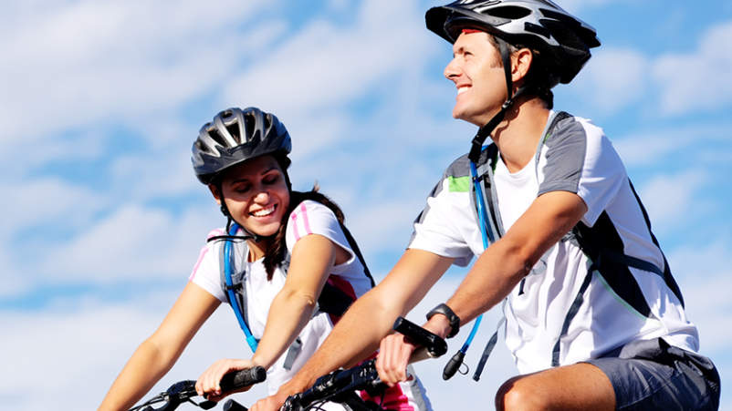 微笑的夫妇在骑自行车的时候休息。