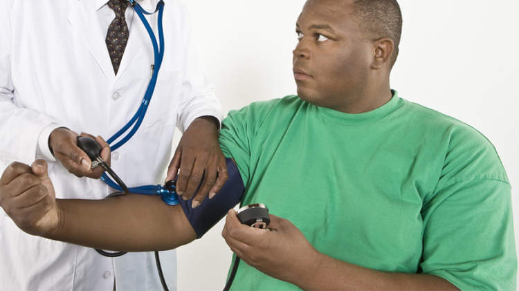 超重年轻的黑人男子安排他的血压测量。