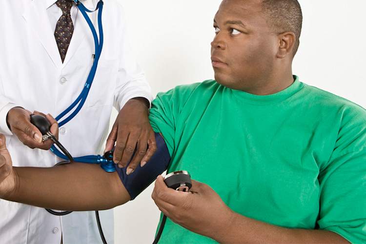 超重年轻的黑人男子安排他的血压测量。