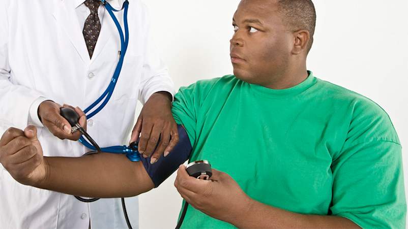 超重年轻的黑人男子安排他的血压测量。