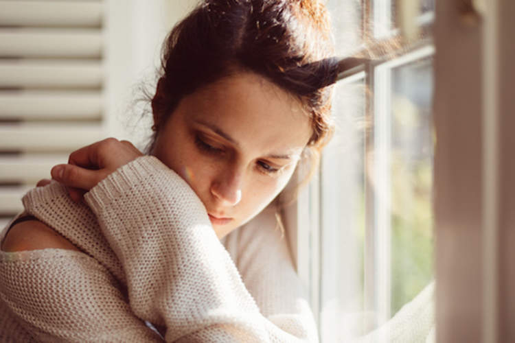 忧心忡忡的年轻女子望着窗外。