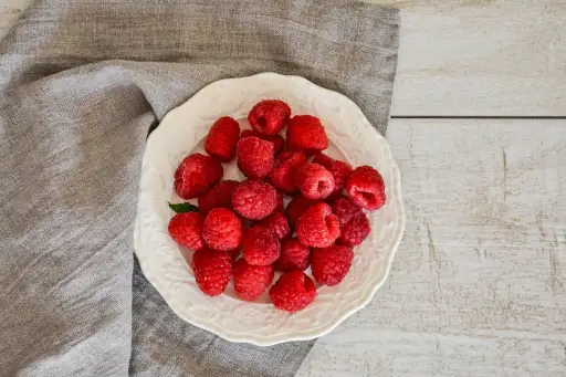 在一个碗的莓在灰色餐巾和木桌上顶部
