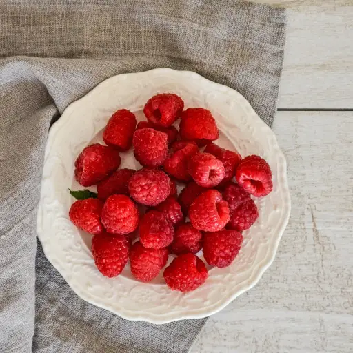 在一个碗的莓在灰色餐巾和木桌上顶部