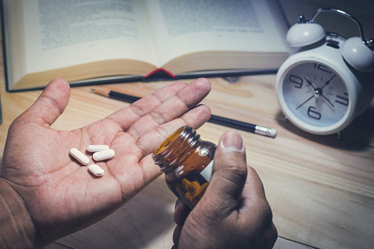 男子在晚上服用维生素。