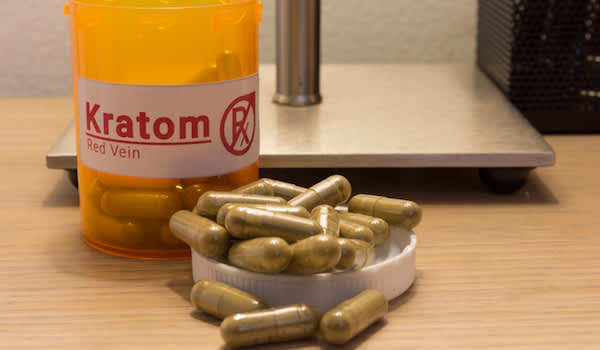 Kratom药瓶和kratom胶囊在床头柜上。