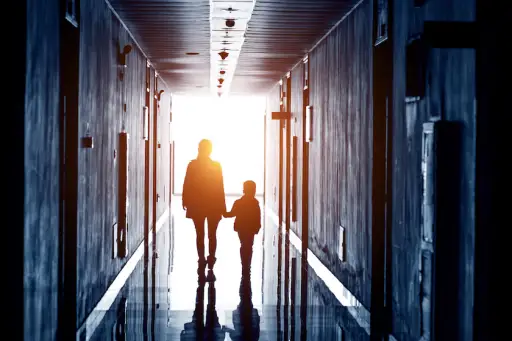 父母和孩子沿着走廊走向光明。