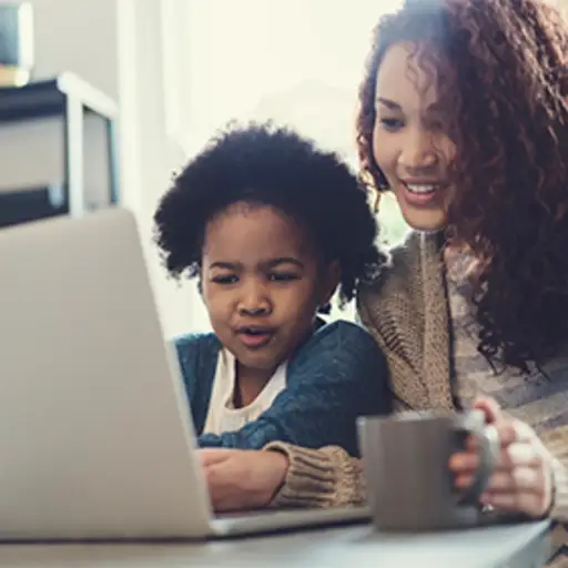 母亲和年轻女儿膝上型计算机的。