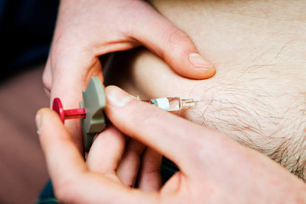 男子注射生物药物来治疗类风湿性关节炎。