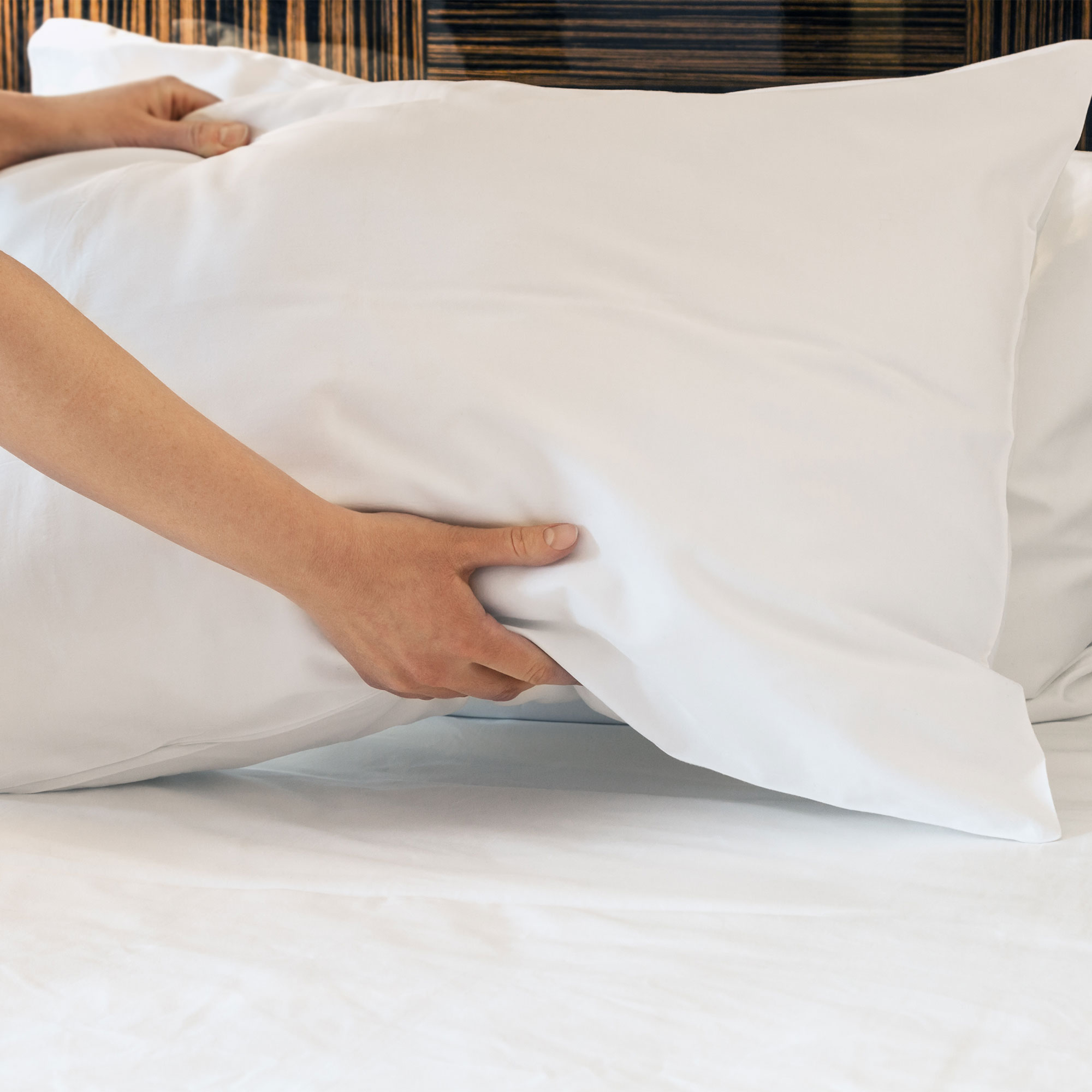 一个女人从床上拿起枕头