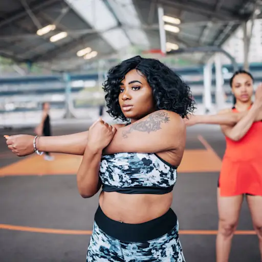 overweight young woman stretching during exercise class