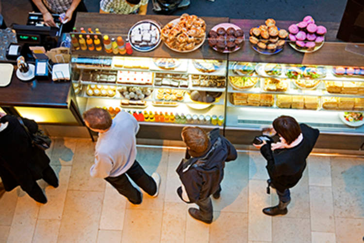 人们在餐馆柜台前排队。