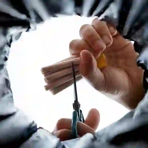 从下面看,一个男人把香烟切成两半