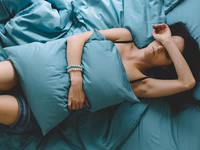 生病的女人在床上的枕头举行。