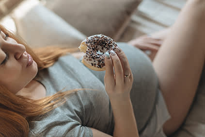 孕妇吃甜甜圈。