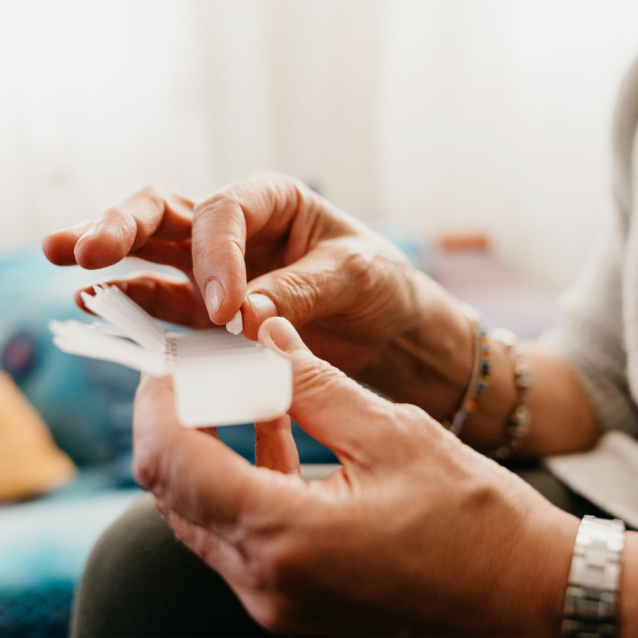 一个人从药丸盒里拿起一颗药丸