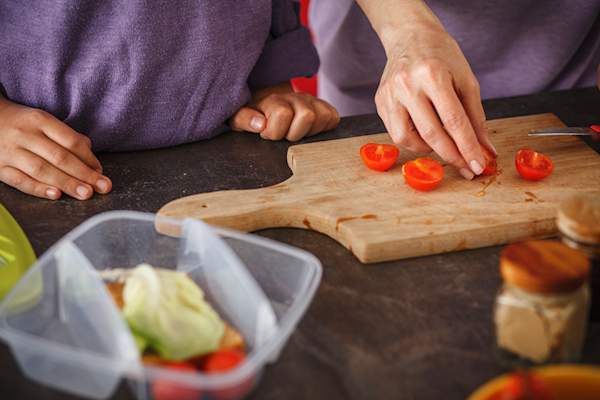 母亲和孩子的切割樱桃西红柿